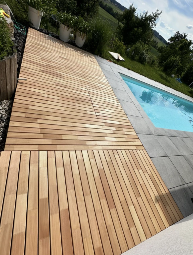 Projekte: Moderne Holzterrasse neben einem Pool, mit natürlichen Holzlatten in einem stilvollen Außenbereich.